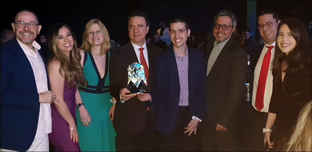 At center, wearing a red tie, is Kami Saidi, HP Brazil's head of manufacturing for supply chain transformation and resilience. Alongside Saidi is Diego Mutta, wearing a blue jacket, as they celebrate their achievement with the HP Brazil team.