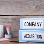 Company and Acquisition. Two binders on desk in the office. Business background